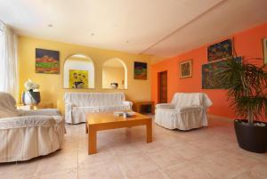 a living room with two white chairs and a table at PINOS ALTOS 16 in Cala de Sant Vicenc +20 photos