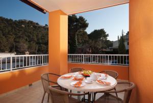 a table with a bowl of fruit on a balcony at PINOS ALTOS 16 in Cala de Sant Vicenc