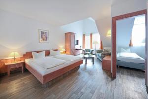 a bedroom with a large bed and a mirror at Waldhotel Bächlein in Mitwitz