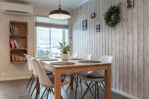 comedor con mesa de madera y sillas blancas en SAGI 5 Apartment, en Hafslo