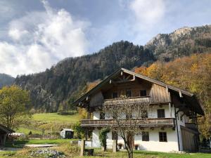 une maison dans un champ avec des montagnes en arrière-plan dans l'établissement Cuka Designhome Aschau, à Aschau im Chiemgau