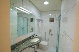 a bathroom with a sink and a shower and a toilet at Locanda Hotel in Novo Hamburgo