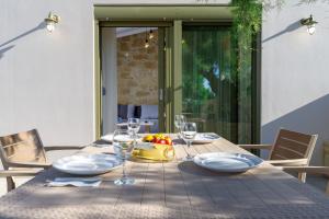 - une table en bois avec des verres et un bol de fruits dans l'établissement Zefyros Apartments and House, à Kíssamos