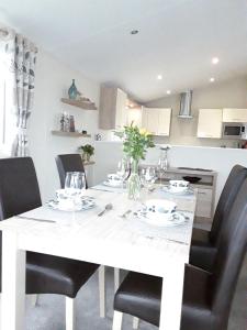 a white table with black chairs in a kitchen at Clearwater Lodge Bude in Poundstock