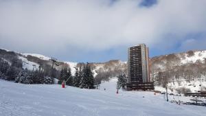 un edificio sobre una pista de esquí cubierta de nieve en Studio-cabine au pied des pistes à Super Besse en Super Besse