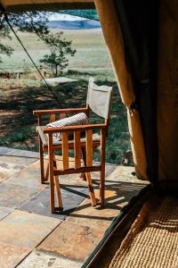a wooden chair sitting on the porch of a house at Cradlestone Camp in Krugersdorp