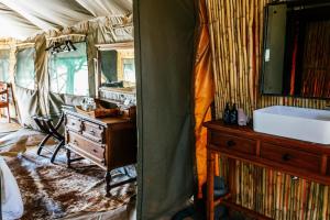 a bedroom with a sink and a dresser and a mirror at Cradlestone Camp in Krugersdorp