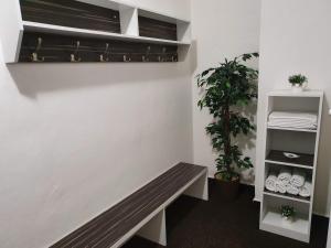 a bench in a room with a plant and towels at Penzion Starr in Havlíčkŭv Brod