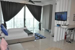 a bedroom with a bed and a flat screen tv at Kompleks EVO Syamimi Homestay in Bangi