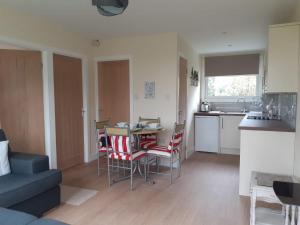 a living room with a kitchen and a table and chairs at 13 The Park in Kilkhampton