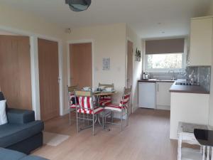 a living room with a kitchen and a table and chairs at 13 The Park in Kilkhampton +17 photos