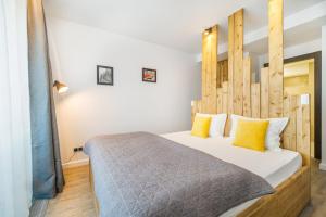 a bedroom with a large bed with a wooden headboard at Cosy Loft flat in Silver Mountain of Poiana Brasov in Poiana Brasov
