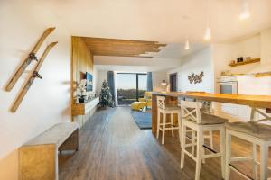 a kitchen and living room with a table and chairs at Cosy Loft flat in Silver Mountain of Poiana Brasov in Poiana Brasov