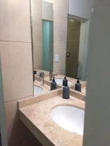 une salle de bain avec deux lavabos et deux miroirs dans l'établissement DEPARTAMENTO DE 2 DORMITORIOS C/ COCHERA, à Villa María