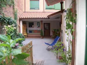 un patio con una sedia blu e alcune piante di Apartamento en el Casco Histórico, frente a la Colegiata de San Isidoro, a León