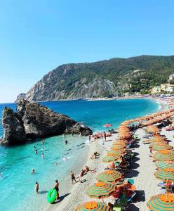 Grupa ludzi na plaży z parasolami w obiekcie Appartamento Ca’ del Gian w mieście La Spezia