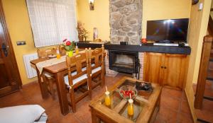 a living room with a table and a fireplace at El Bulín de Braojos - 3 Casas in Braojos de la Sierra