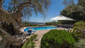 a swimming pool with an umbrella and a table and chairs at Casa Bonaire Esporles in Esporles