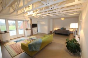 uma grande sala de estar com uma cama e um sofá em Villa de Hazelaar em Schoorl