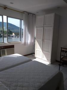 アングラ・ドス・レイスにあるAngra dos Reis - Porto Caieira, RJのベッドルーム1室(ベッド1台、大きな窓付)