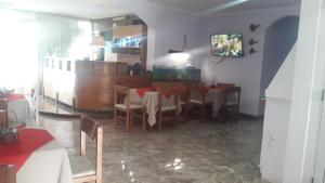 a dining room with a table and chairs and a tv at HOTEL SAN JORGE in San Clemente