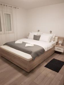 a white bedroom with a large bed with white walls at Luxury APP Anna ( near center) in Crikvenica