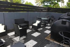 a patio with chairs and tables and a fence at Donfarsha Apartments in Paramaribo