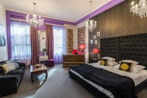 a bedroom with a large bed and a couch at Janus Boutique Hotel & Spa in Siófok