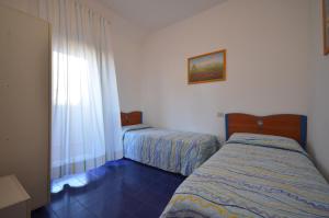 a bedroom with two beds and a window at Villaggio Marina in Bibione