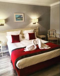 ブジーグにあるLa Côte Bleueのベッドルーム1室(大型ベッド1台、赤と白のシーツ付)