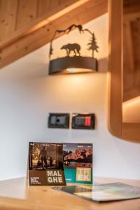 un livre assis sur une table sous une lumière dans l'établissement Hotel Genzianella, à Commezzadura