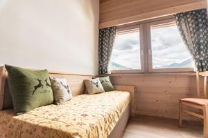 a bedroom with a bed and a window at Hotel Genzianella in Commezzadura