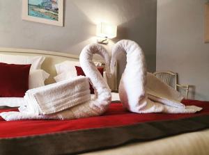two towel swans sitting on top of a bed at La Côte Bleue in Bouzigues