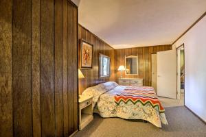 a bedroom with wooden walls and a bed and a desk at Quaint and Rustic A-Frame Less Than 5 Mi to Plumas-Eureka! in Plumas Eureka