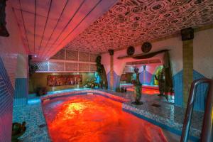 a swimming pool in a room with a colorful ceiling at Janus Boutique Hotel & Spa in Siófok
