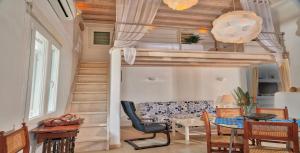 a room with a loft bed with a couch and a table at Ortus Ivory Mykonian Lux Villa With POOL! in Mýkonos City