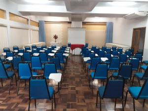 a lecture room with blue chairs and a whiteboard at HOTEL TAIÓ in Taió