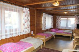 a bedroom with three beds in a wooden house at Dom Gościnny u Stochów in Zakopane