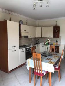 uma cozinha com armários brancos e uma mesa e cadeiras em Mellieha Seaside Apartment em Mellieħa