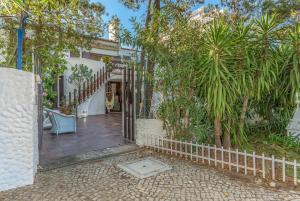 una entrada a una casa con árboles y una valla en FLH Monte Gordo Family Villa, en Monte Gordo