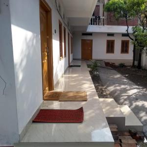 una entrada a un edificio con una puerta y una alfombra roja en Manipur House, en Imphal