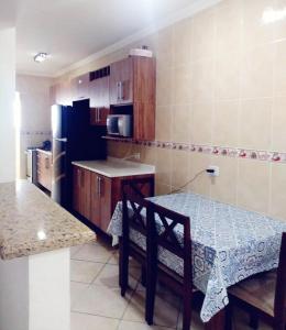 a kitchen with a table and a kitchen with a refrigerator at Apartamento Praia Grande Pé na areia in Solemar