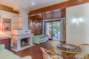 a living room with a fireplace and a table and chairs at FLH Monte Gordo Family Villa in Monte Gordo