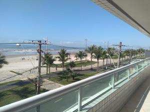 a balcony with a view of the beach at Apartamento Praia Grande Pé na areia in Solemar