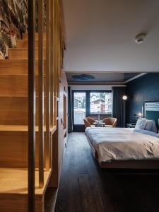 a bedroom with a large bed and a staircase at Hotel National Zermatt in Zermatt