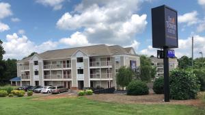 a large building with a sign in front of it at Intown Suites Extended Stay Select Charlotte NC - University in Charlotte
