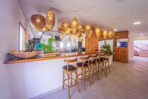 a kitchen with a bar with bar stools at Hostel Central São Sebastião in São Sebastião