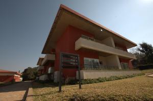ein rotes Gebäude mit Balkon auf der Seite in der Unterkunft Songo Hotel By Montebelo in Songo