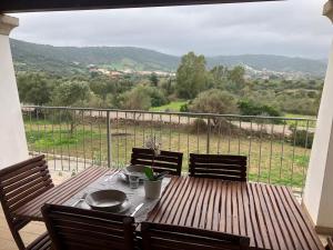 ブドーニにあるTrilocale con terrazzaの木製テーブルと椅子付きのバルコニーから眺めの良い景色を楽しめます。