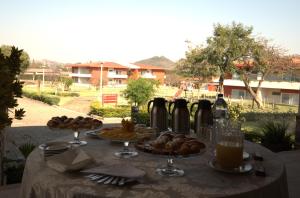 una mesa con platos de comida y una botella de vino en Songo Hotel By Montebelo, en Songo